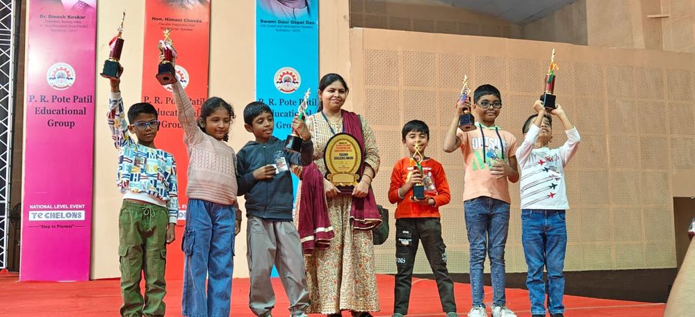 Students raising trophies on stage at Techelons National Level Event
