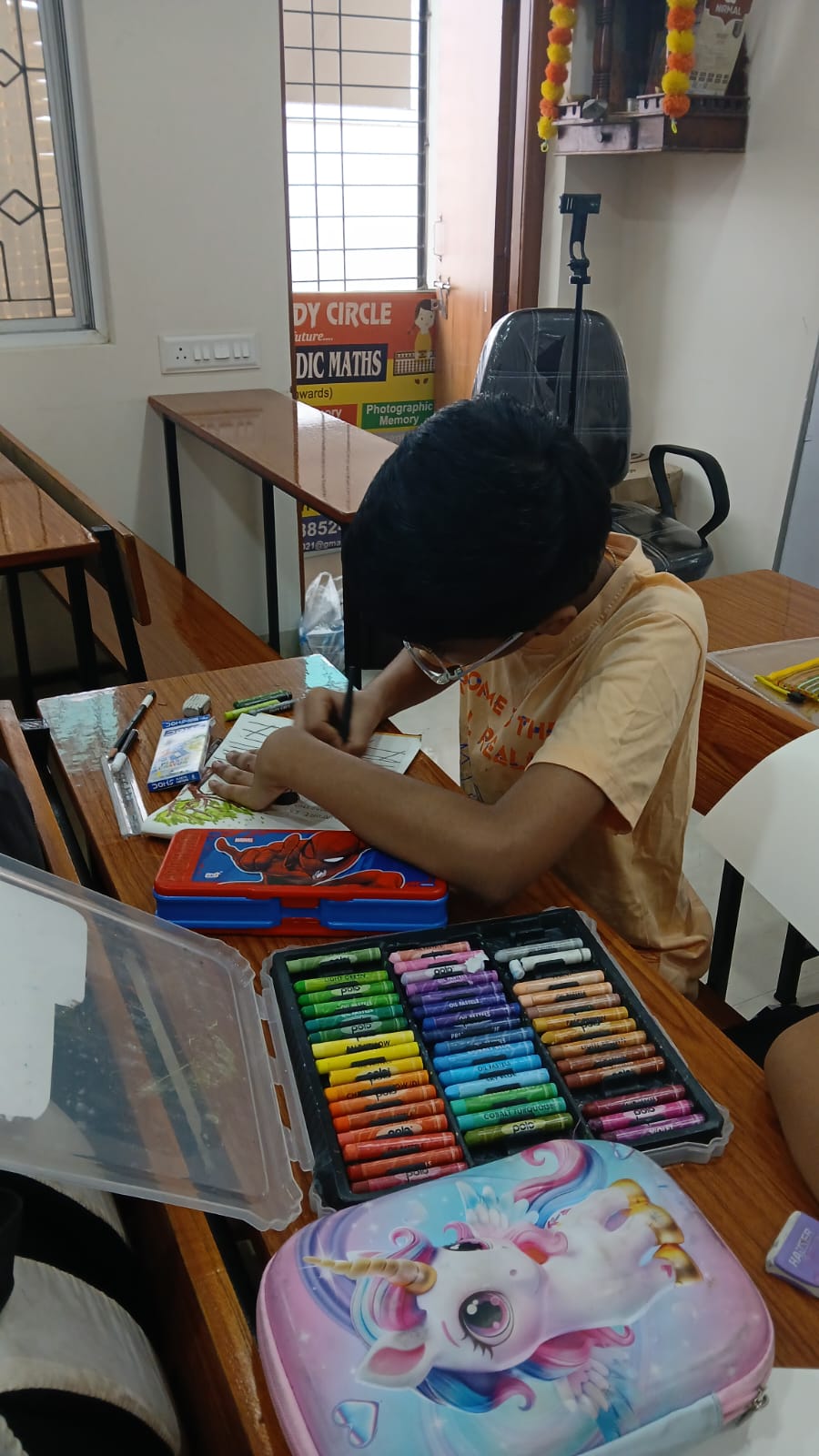 Student working on drawing with crayons and sketch pens at Art Therapy Workshop