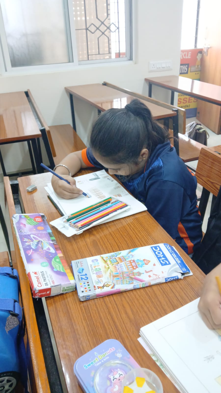 Student drawing with coloured pencils at art therapy session, Manish Nagar Nagpur